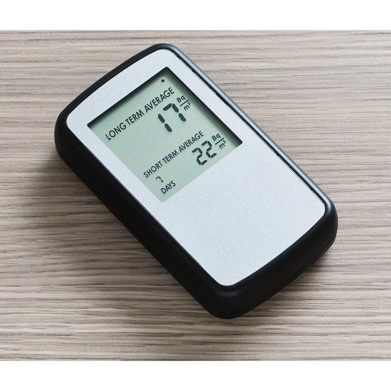 The Airthings Corentium Home radon monitor, a small handheld unit with a digital display.
