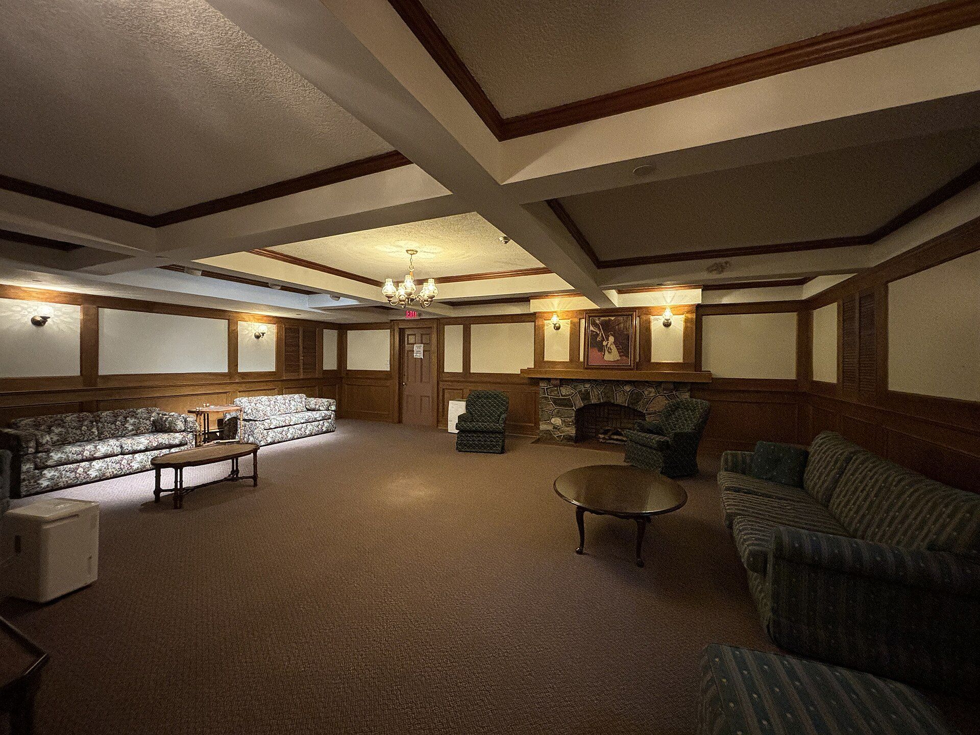 A finished basement room with wood panelling in an older house.