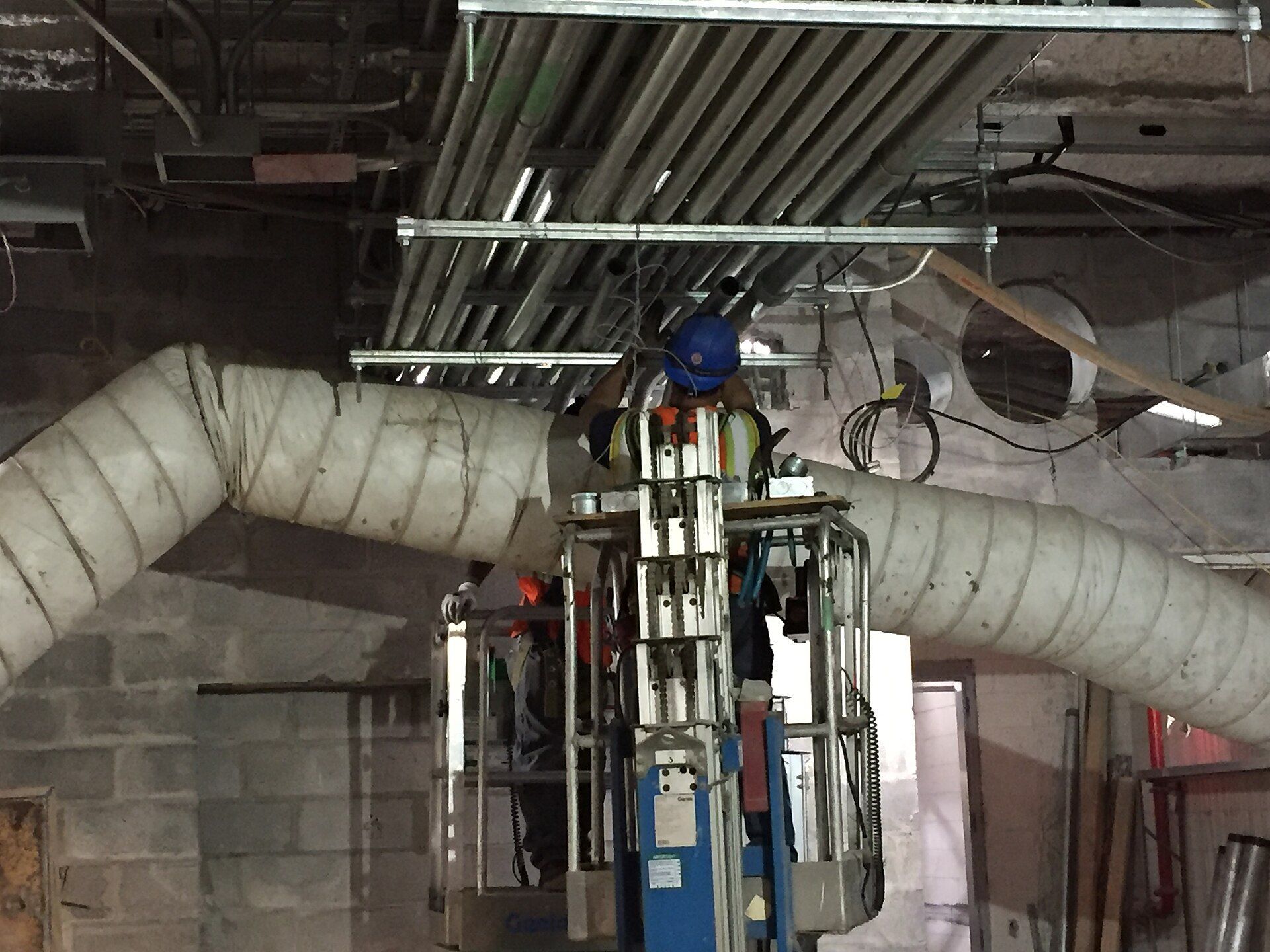 Electricians installing conduit in a building under construction.