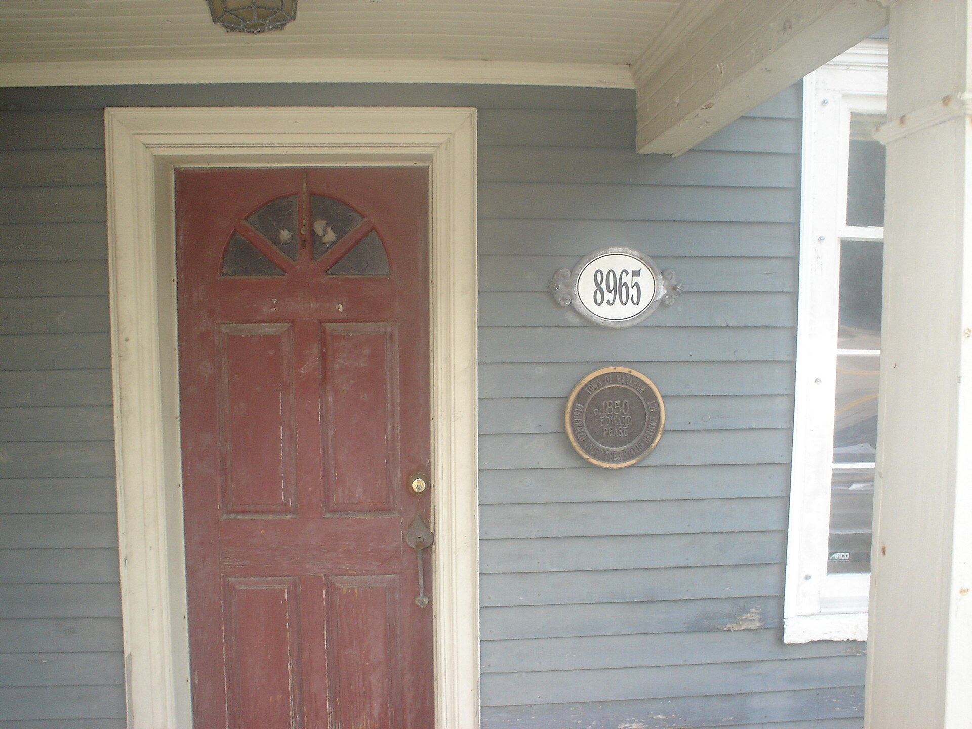 A red front door on a covered porch.