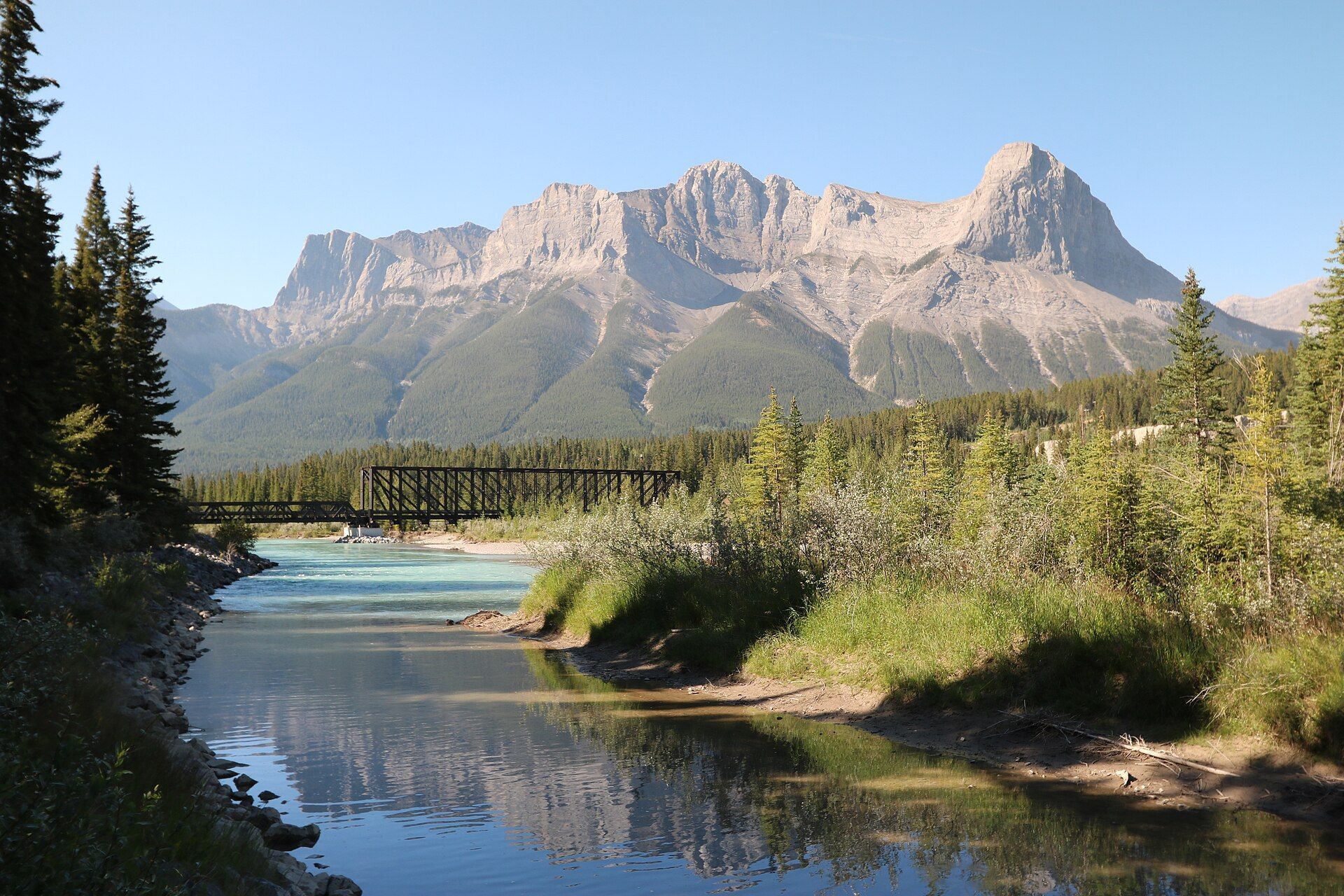 The Bow River in Canmore, Alberta, with mountains behind.