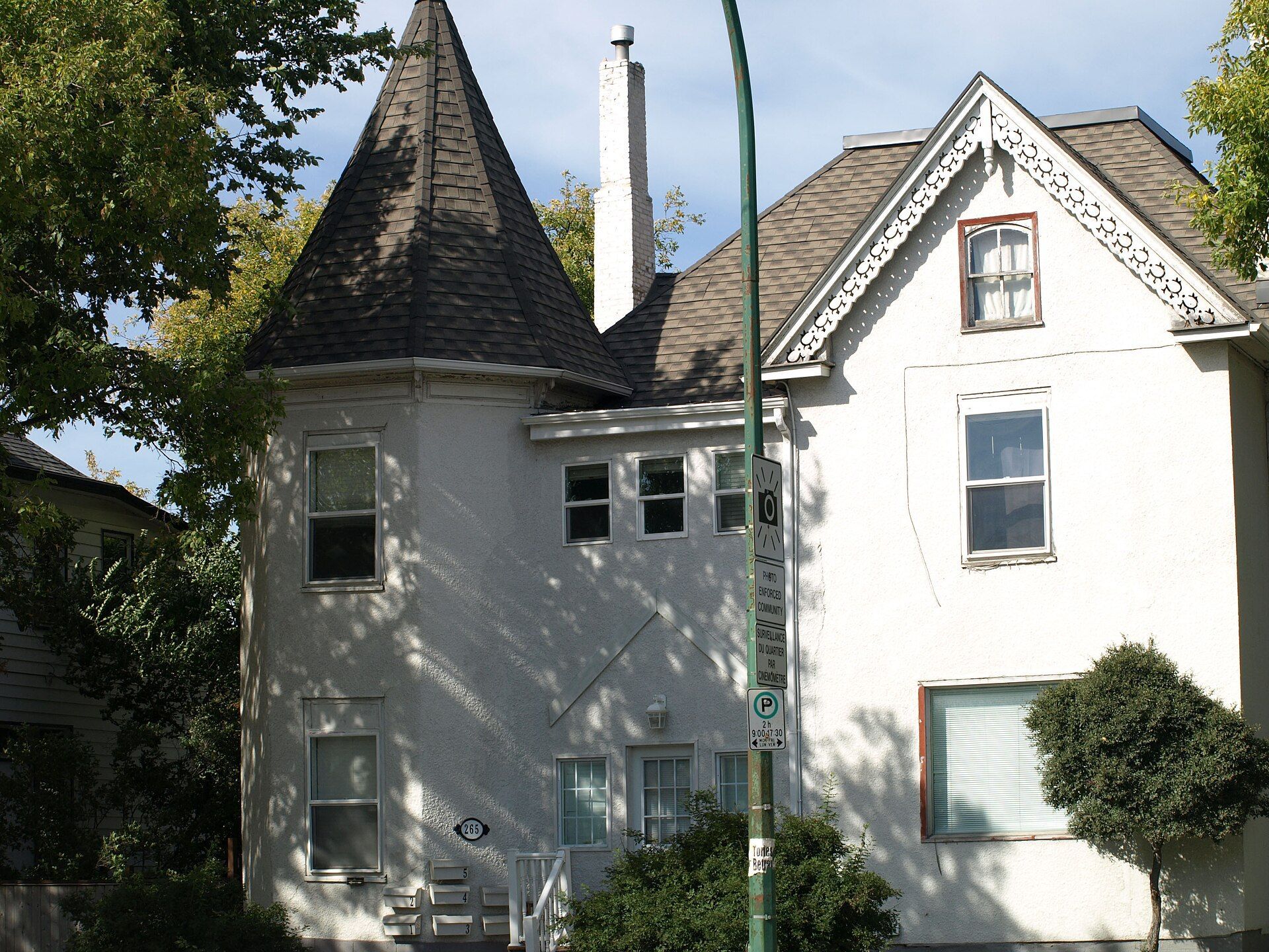 A white house with a steep gabled roof in Winnipeg, Manitoba.