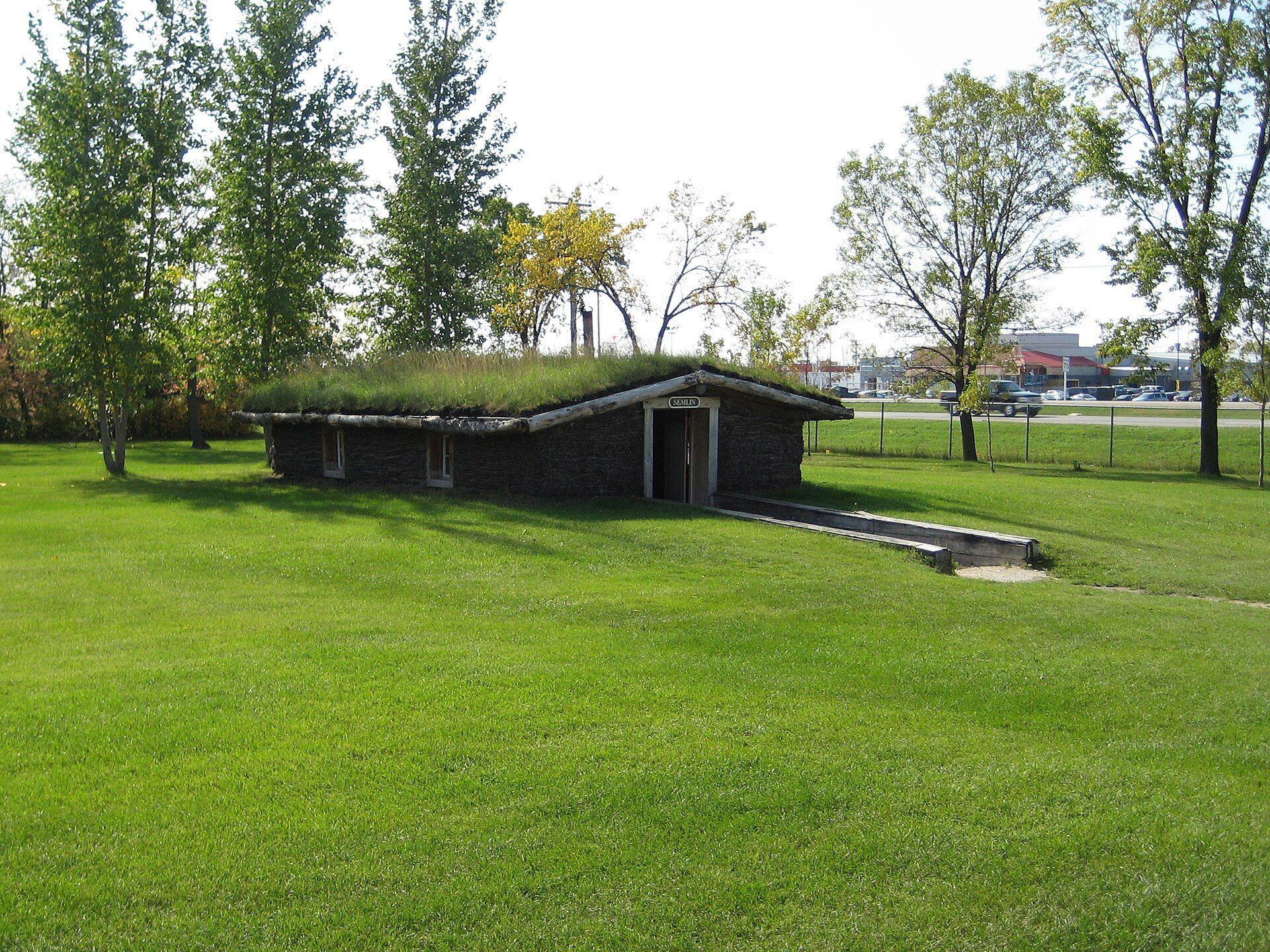 A sod-roofed log building on the lawn of the Mennonite Heritage Village in Steinbach, Manitoba.