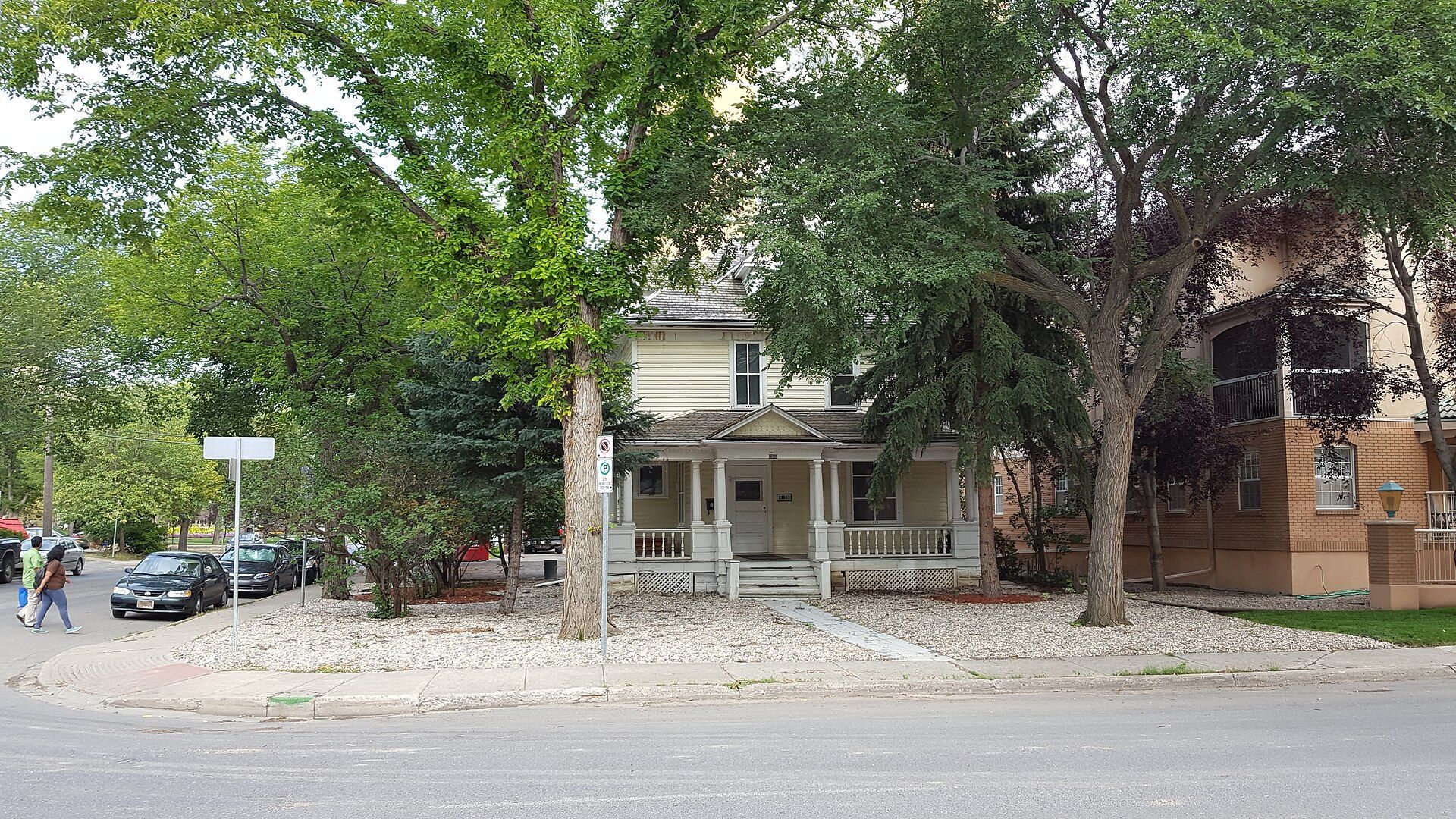 A house with a front porch under tall trees on Cornwall Street in Regina, Saskatchewan.
